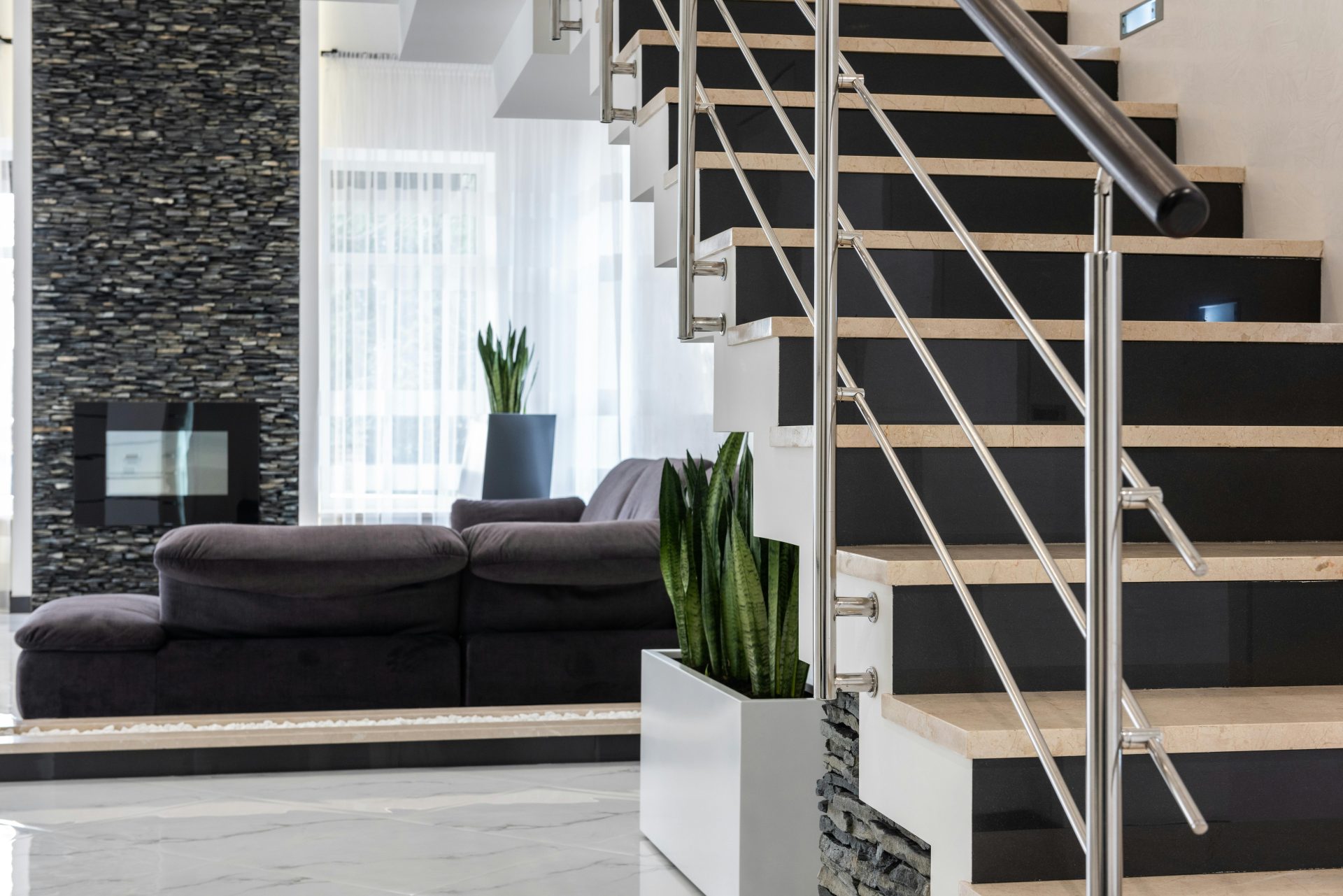 Elegantes, modernes Wohnzimmer mit zeitgemäßer Treppe und stilvoller Einrichtung.